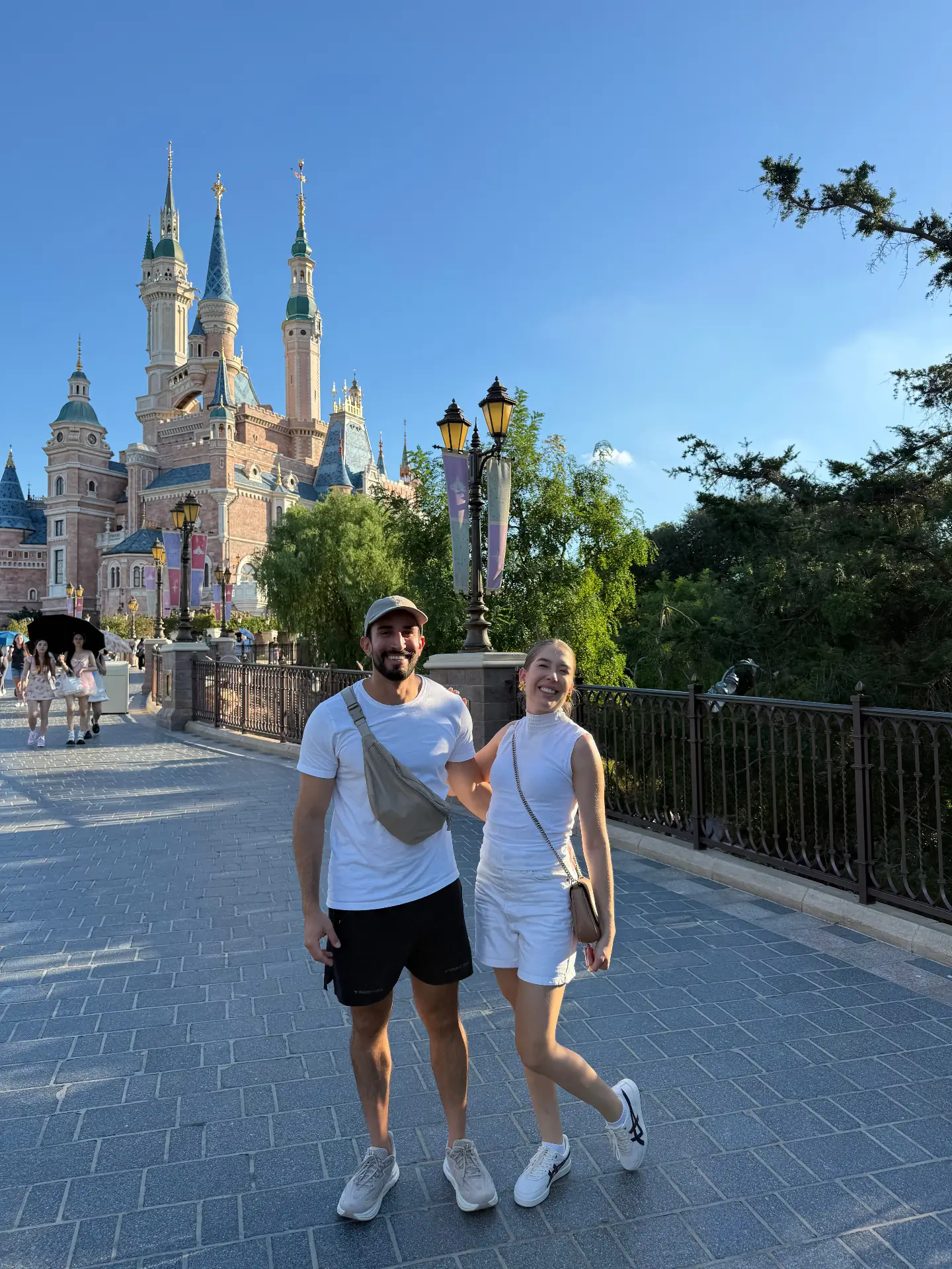 Casal sorrindo em frente ao castelo da Disney em Xangai